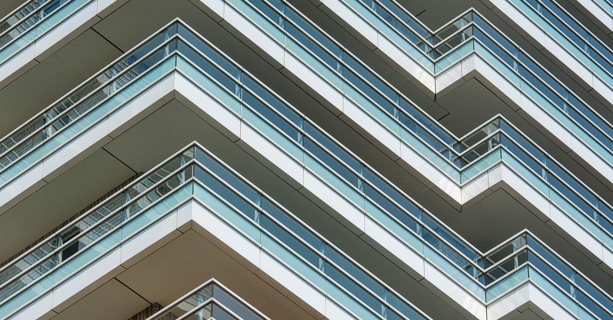The facade of a modern apartment building with glass balconies.