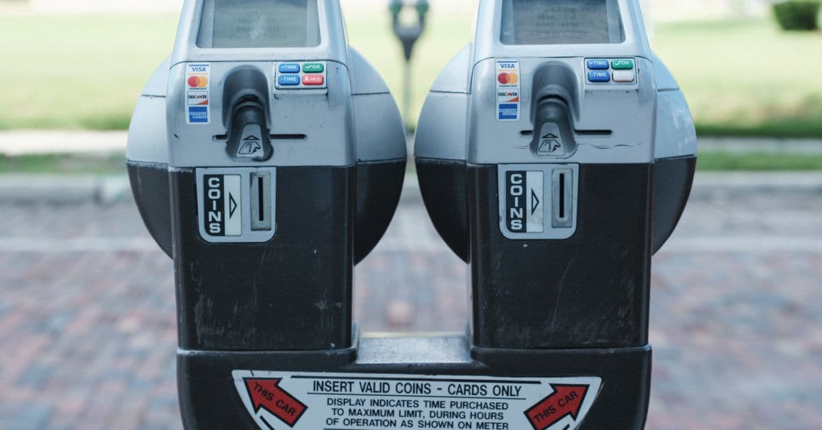 Photo of two parking meters in Orlando showing coin and card payment options on a brick road.