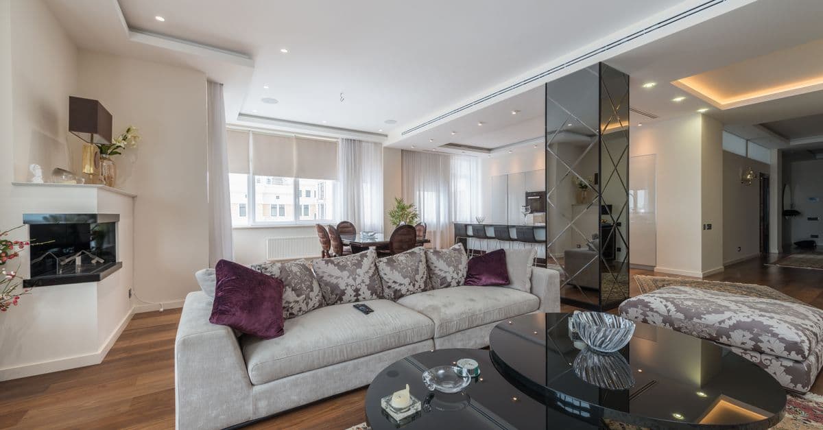 A spacious, light-filled living room in a modern apartment during the day.