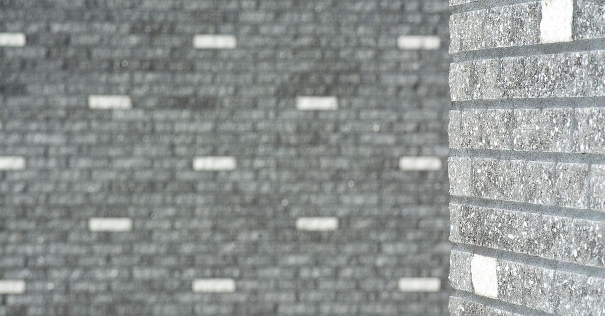 A close-up of a patterned brick wall with texture and depth.