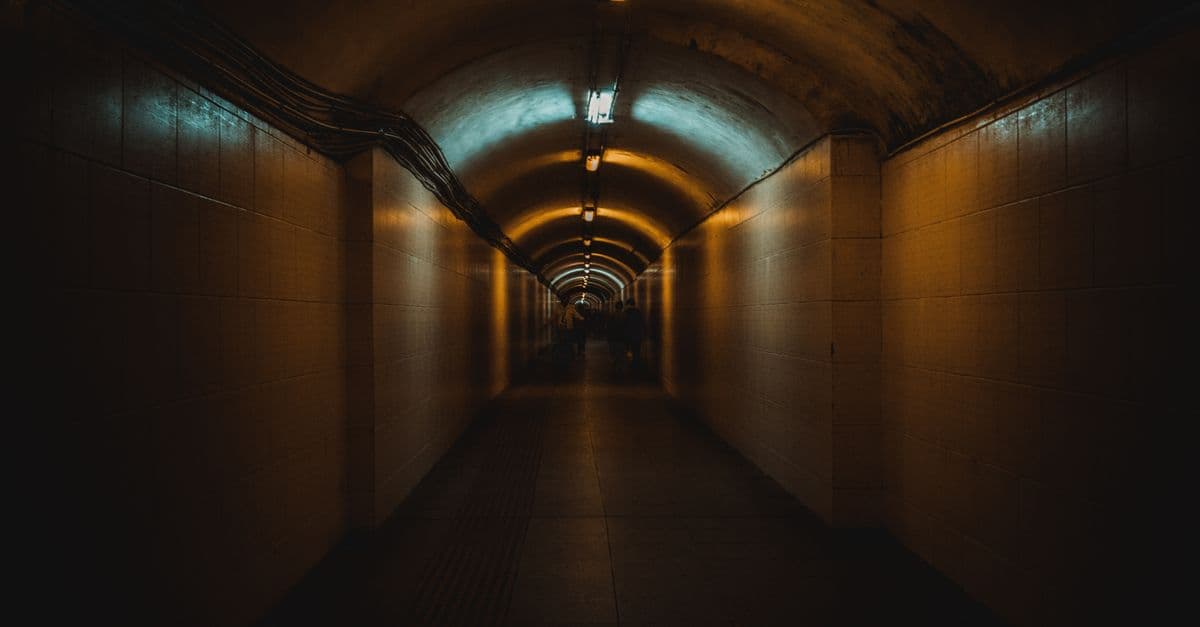 A dimly lit underground tunnel receding into the distance.