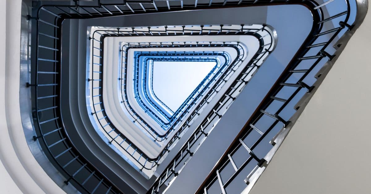 A triangular staircase seen from below, spiralling upward.